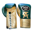 Pair of green and gold boxing gloves with branding on a wooden surface