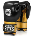 A pair of Cleto Reyes professional boxing gloves in black and gold leather, displayed against a clean white background.
