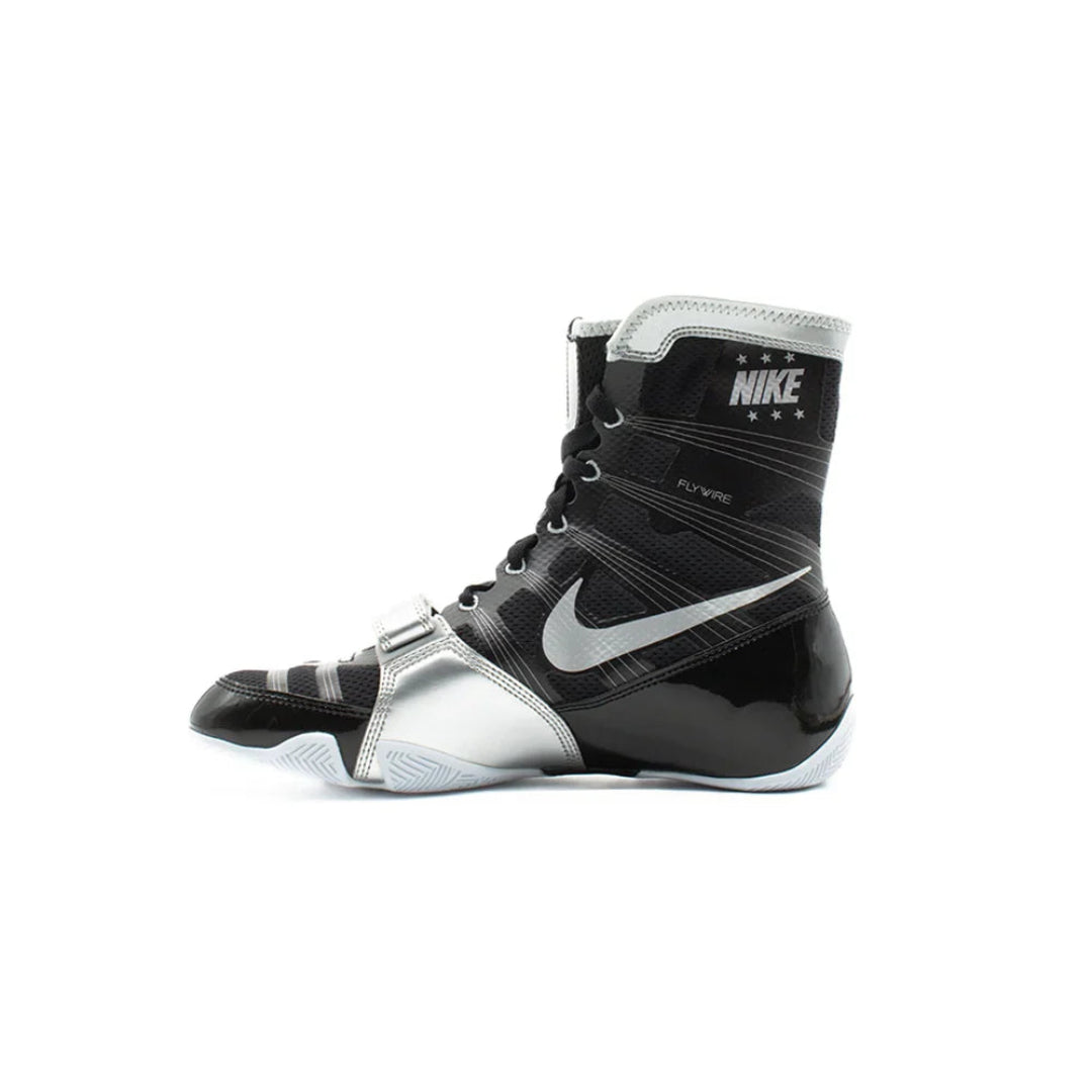 A Nike boxing boot in black and silver, featuring the Nike Swoosh and 'NIKE BOXING' branding on the ankle collar, shown against a plain white background.