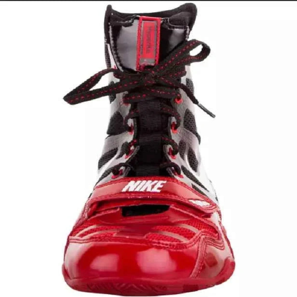 A Nike high-top sneaker in red and black, featuring a glossy red toe cap, black mesh and synthetic panels, and black laces with red stitching, shown against a plain white background.