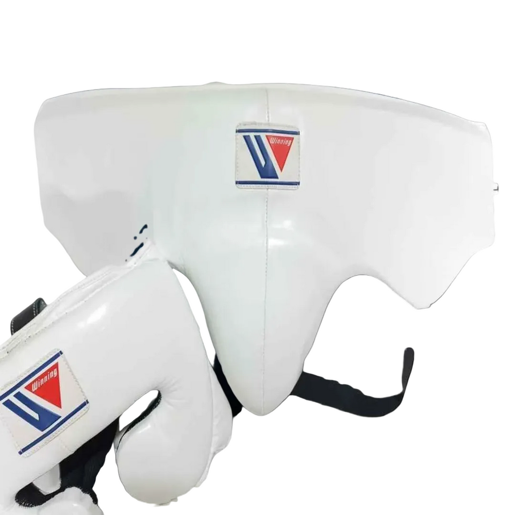 White martial arts headgear and matching gloves with a visible Tri-Star logo patch, shown against a dark blue-to-black gradient background.