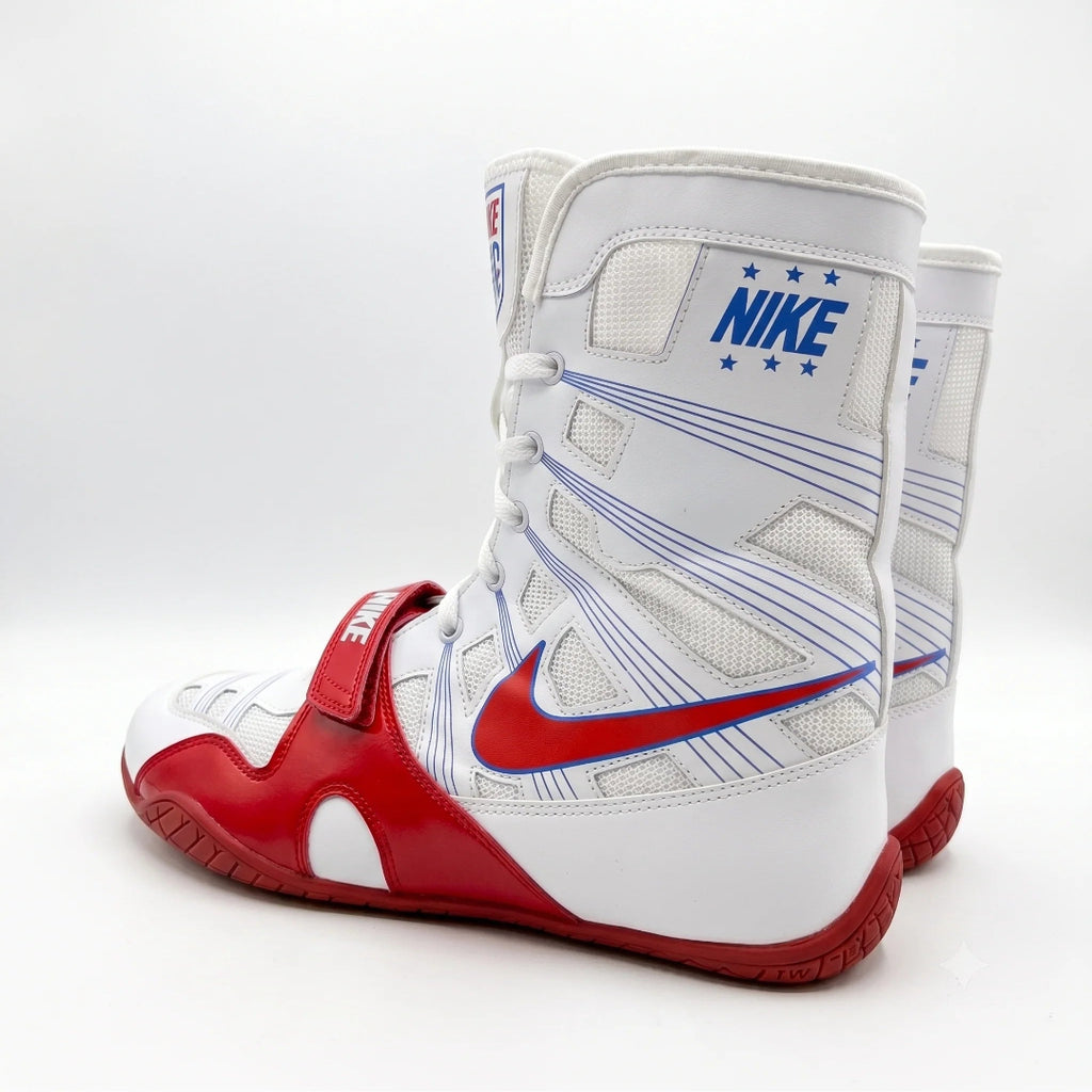 A pair of Nike boxing boots in white, red, and blue, shown from a side angle on a light gray background.