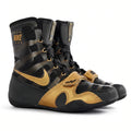 A pair of Nike high-top boxing shoes in black and gold, featuring a patterned upper, gold Swoosh logo, and gold hook-and-loop strap closure, shown on a white background.