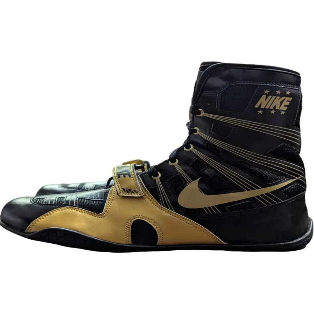 Black and gold boxing shoe with Nike logo on a white background