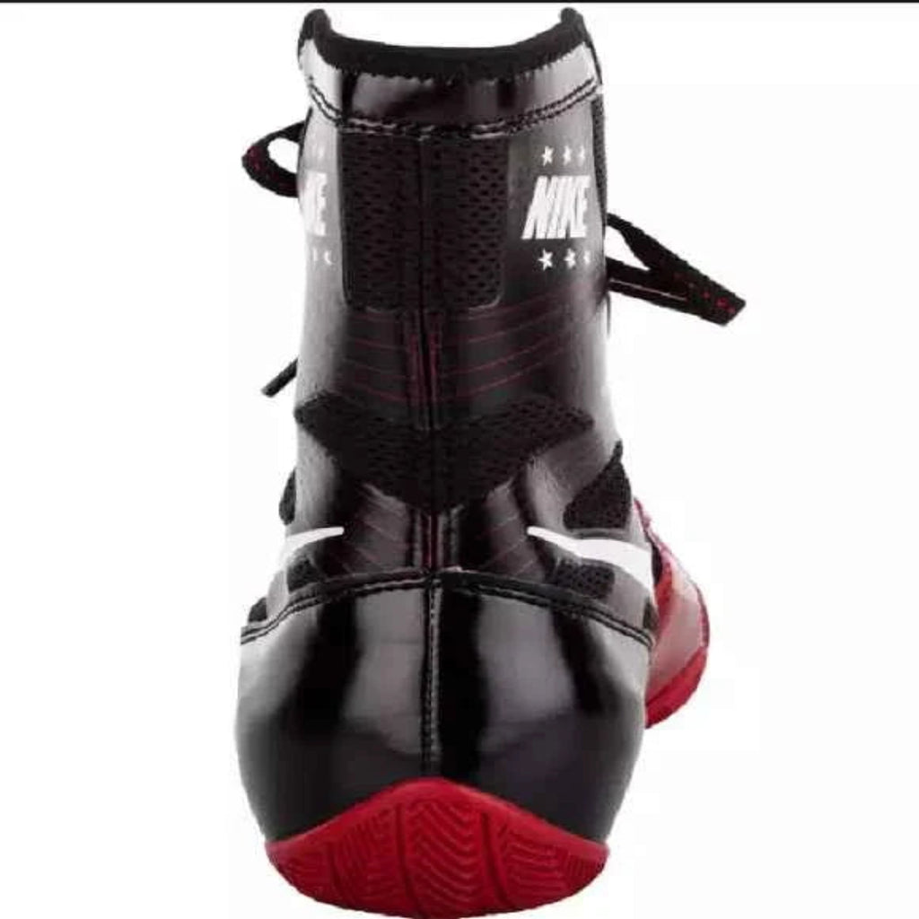 A single high-top athletic shoe shown from the back, featuring a glossy black leather upper with red accents, black mesh panels, white Nike logos, and a red outsole, set against a plain white background.