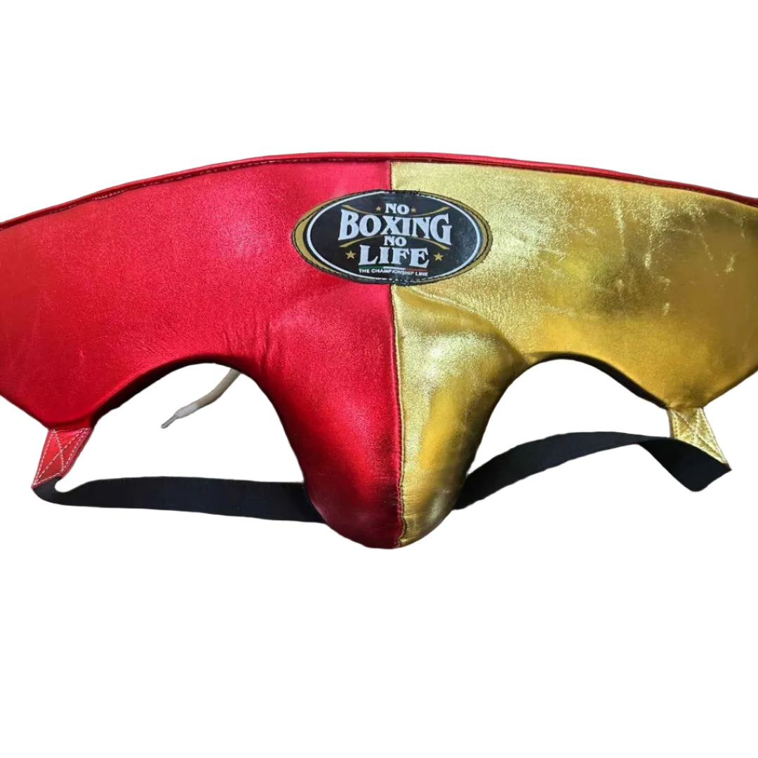 Red and gold boxing headgear with 'No Boxing No Life' label on a wooden surface