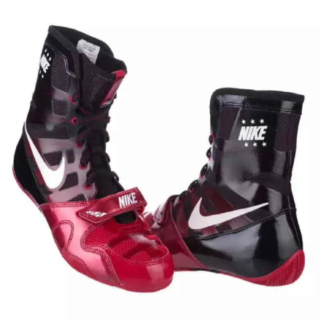 A pair of Nike high-top boxing shoes in black, red, and white, featuring a glossy patent finish, white Swooshes, and Nike branding on the side and tongue.